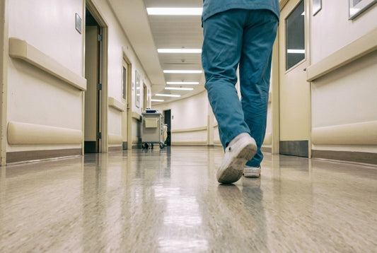 Soignant en station debout dans un couloir, sollicitation du pied